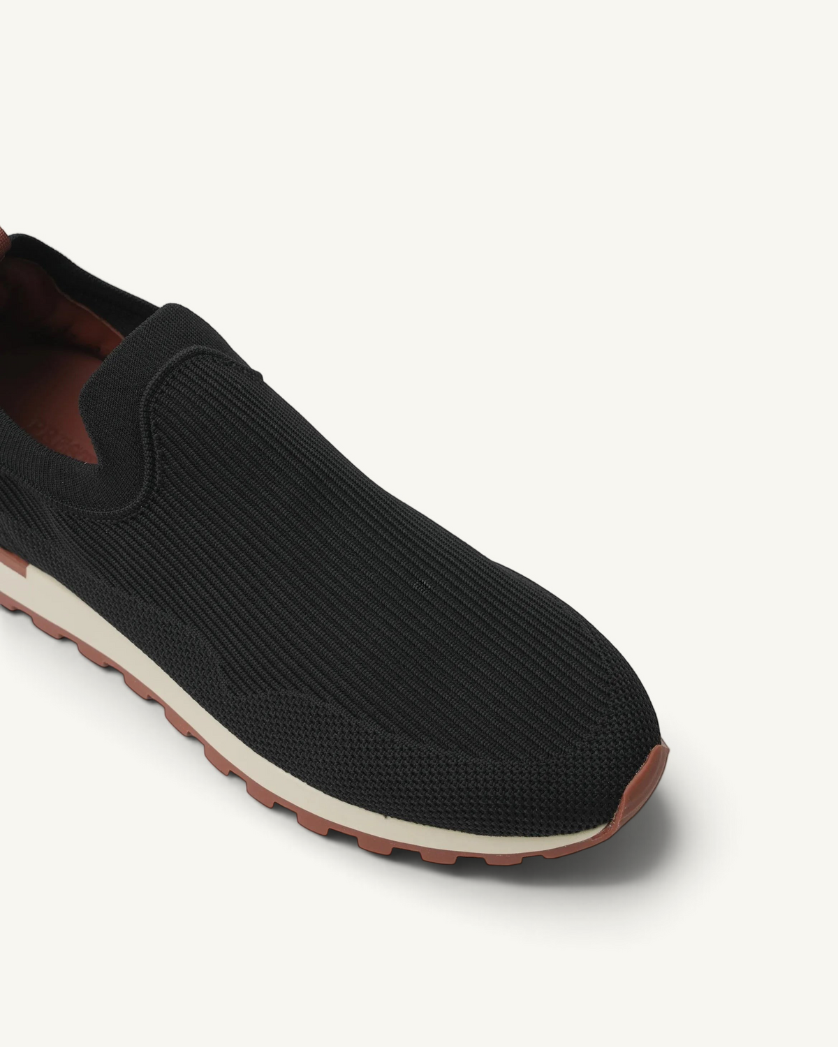 Prestige Flexy Lux active runner in black knit fabric with a slip-on design and a contrasting beige and brown sole.
