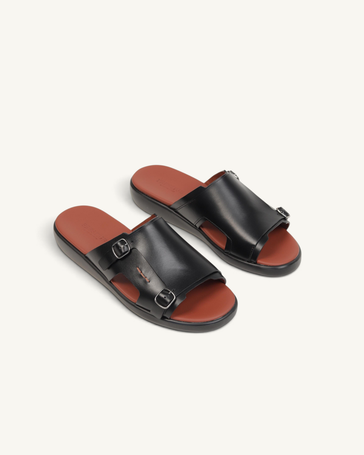 Prestige black soft nappa calf leather slide sandals with double buckle straps and a contrasting brown footbed.