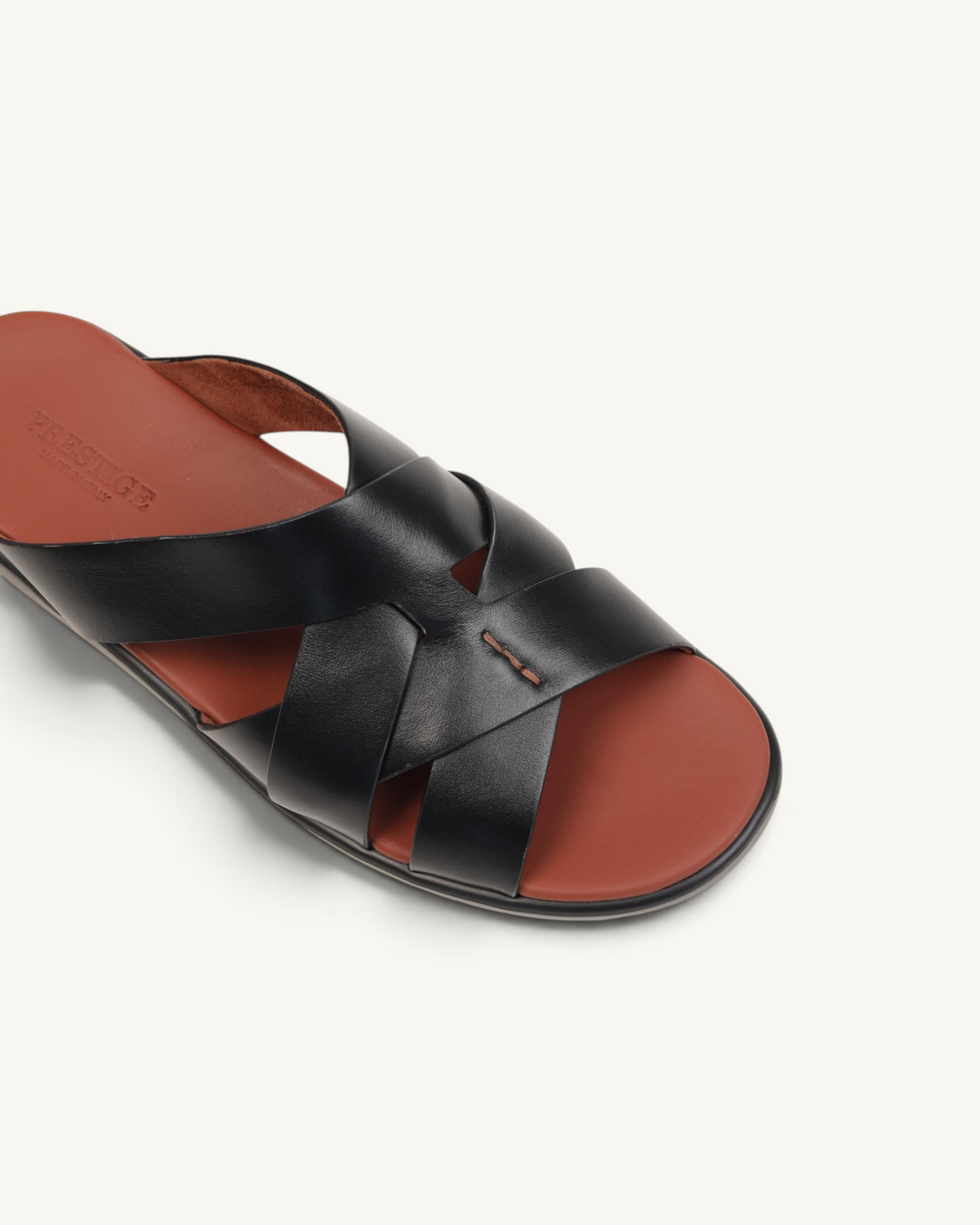 Prestige black soft nappa calf leather slide sandals with a brown footbed and crisscross strap design