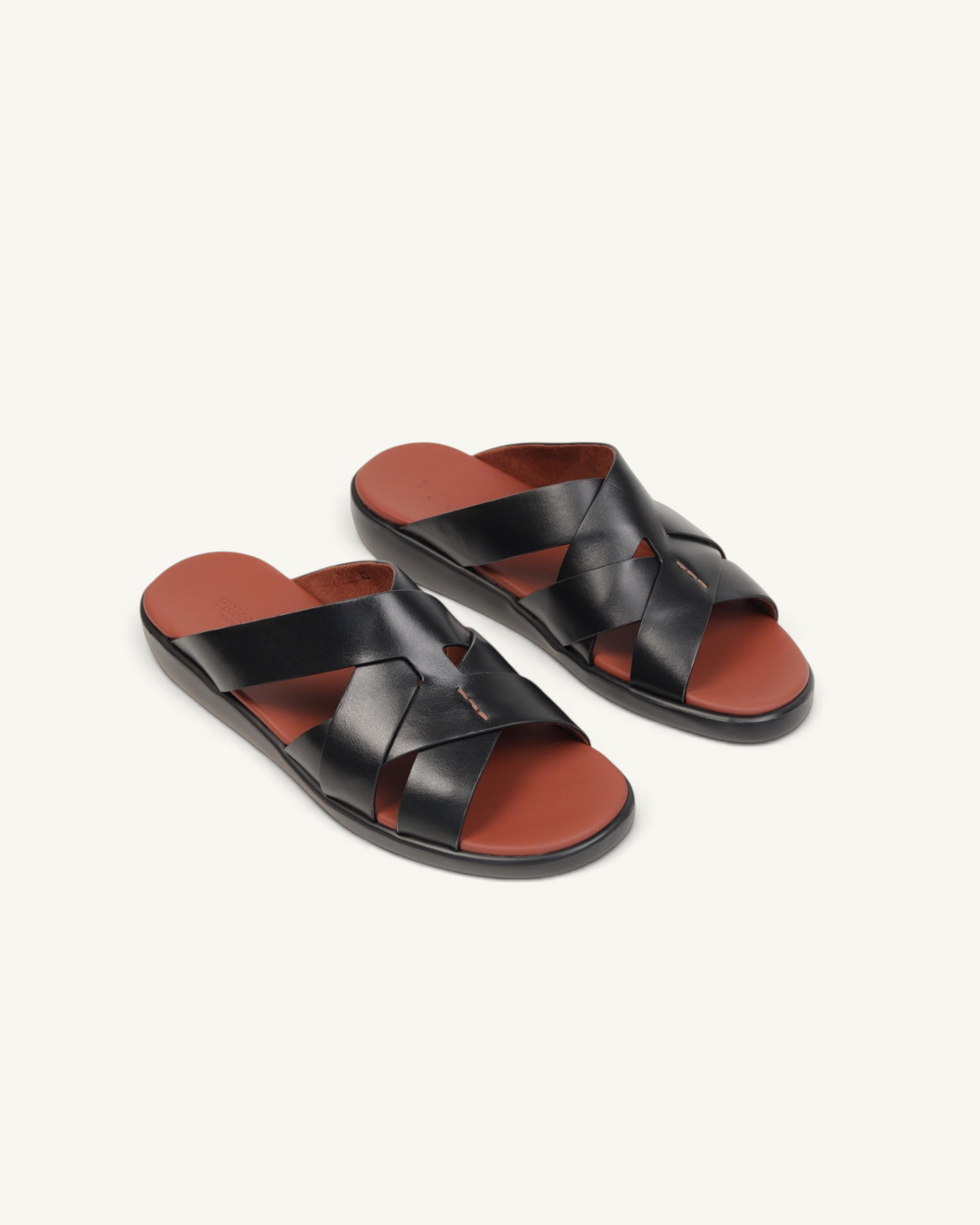 Prestige black soft nappa calf leather slide sandals with a crisscross strap design and brown footbed