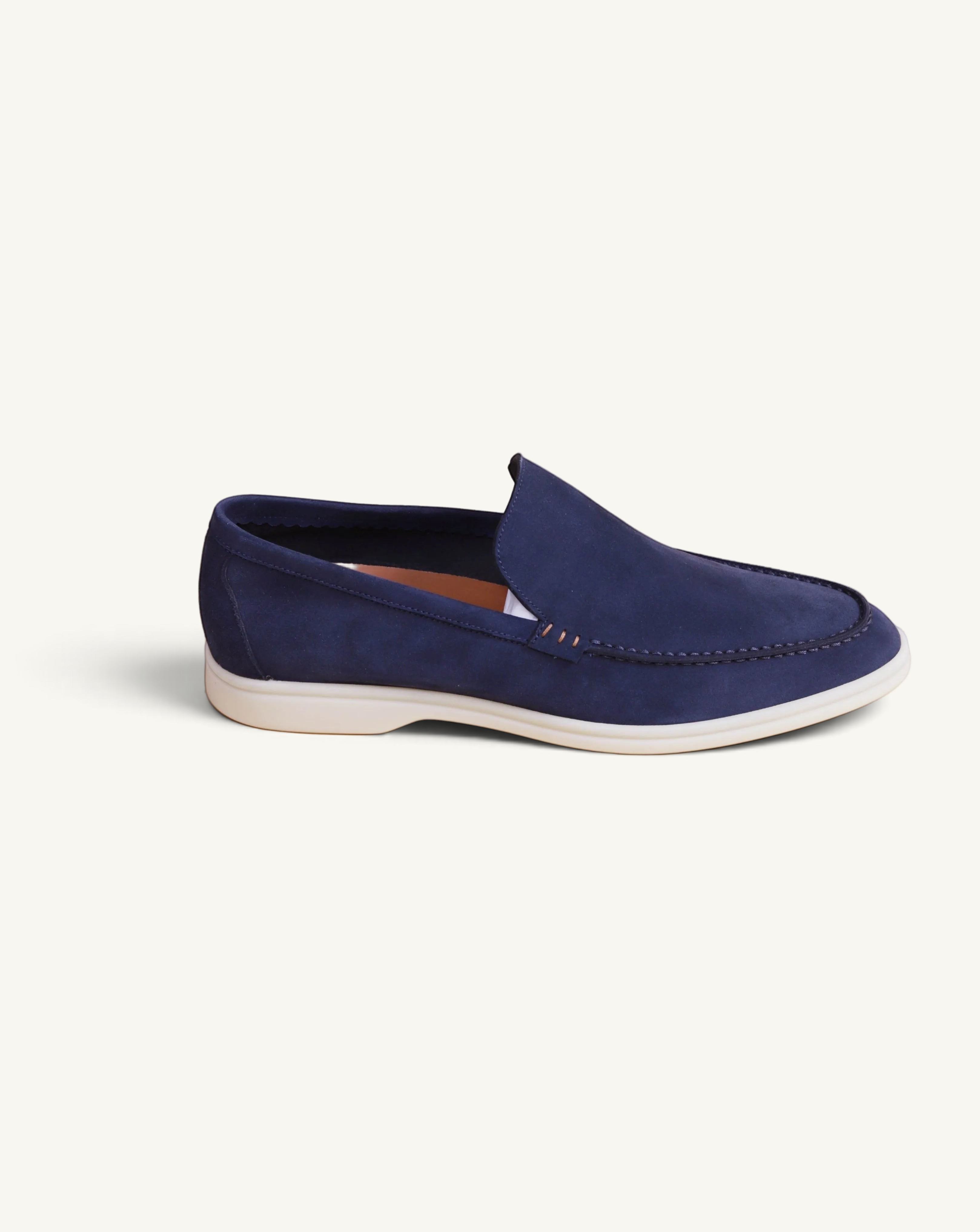 Prestige blue suede loafer with a white rubber sole, featuring a classic slip-on design and moccasin-style stitching.