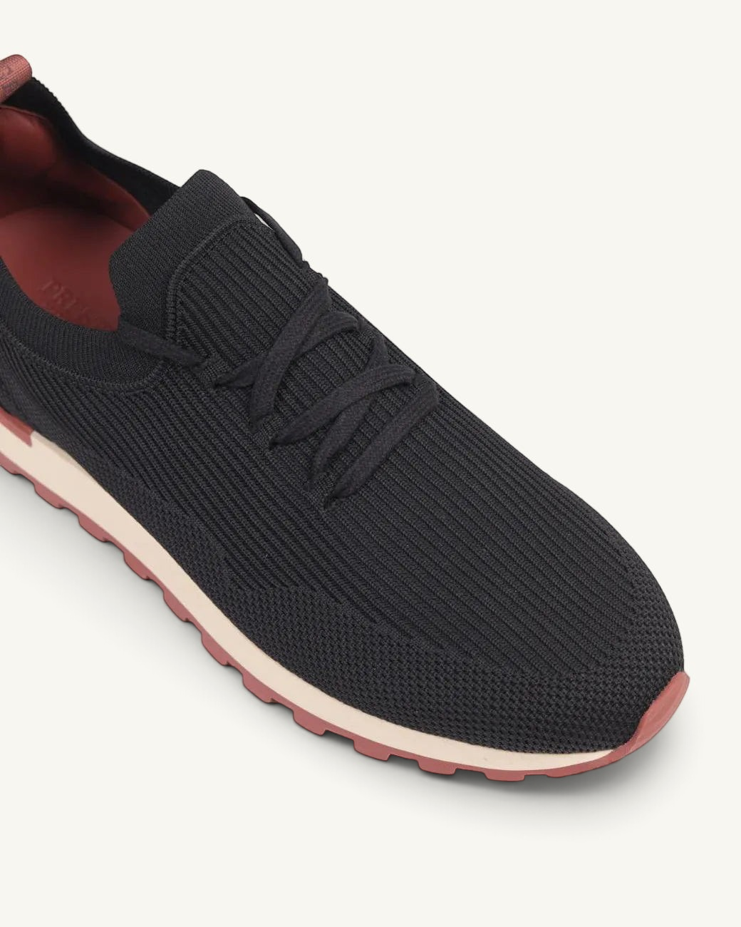 Prestige Flexy Lux black knit sneakers with a ribbed upper, lace-up closure, and a contrasting red and cream sole.