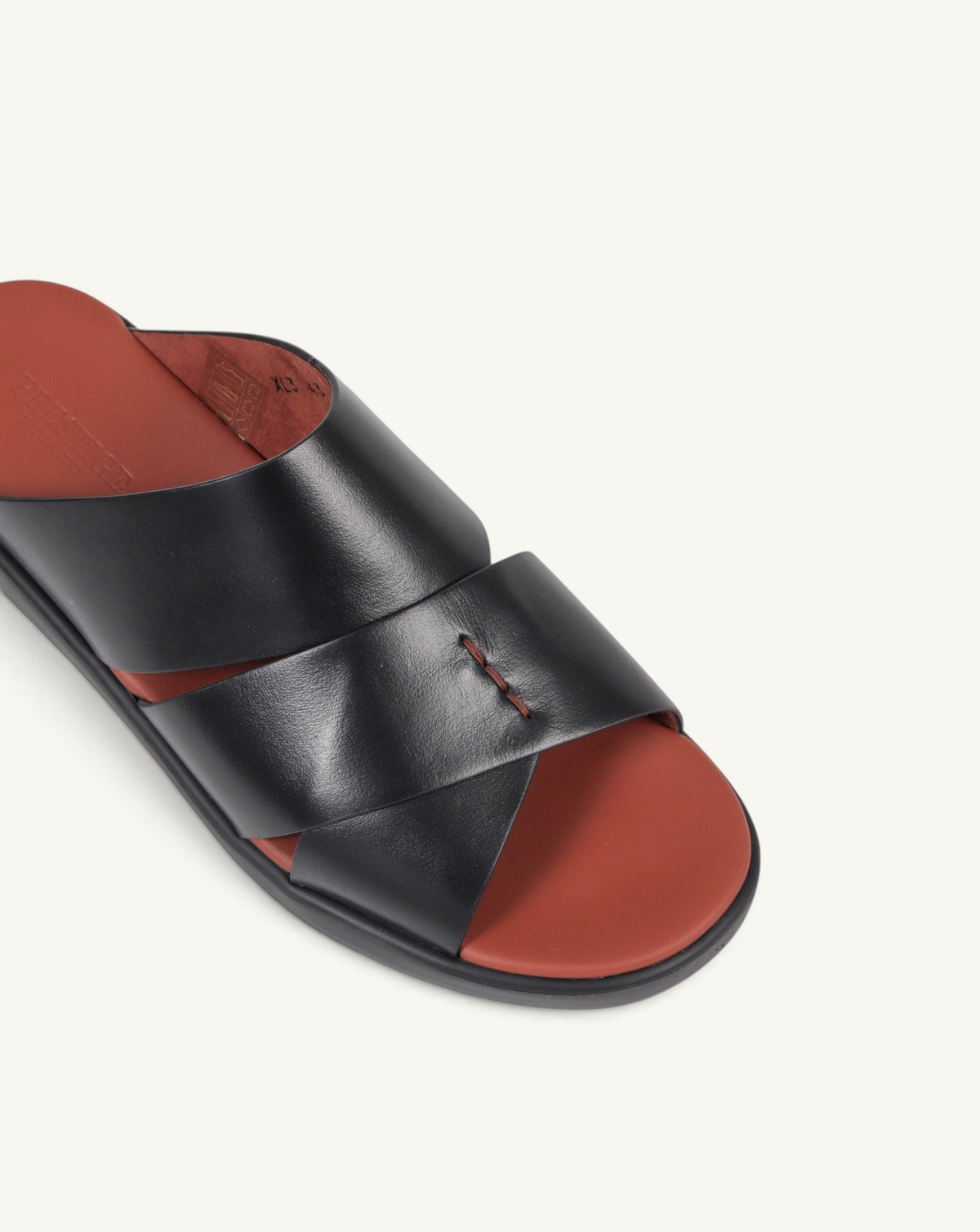 Prestige black soft nappa calf leather slide sandals with a contrasting terracotta footbed and cross-strap design.