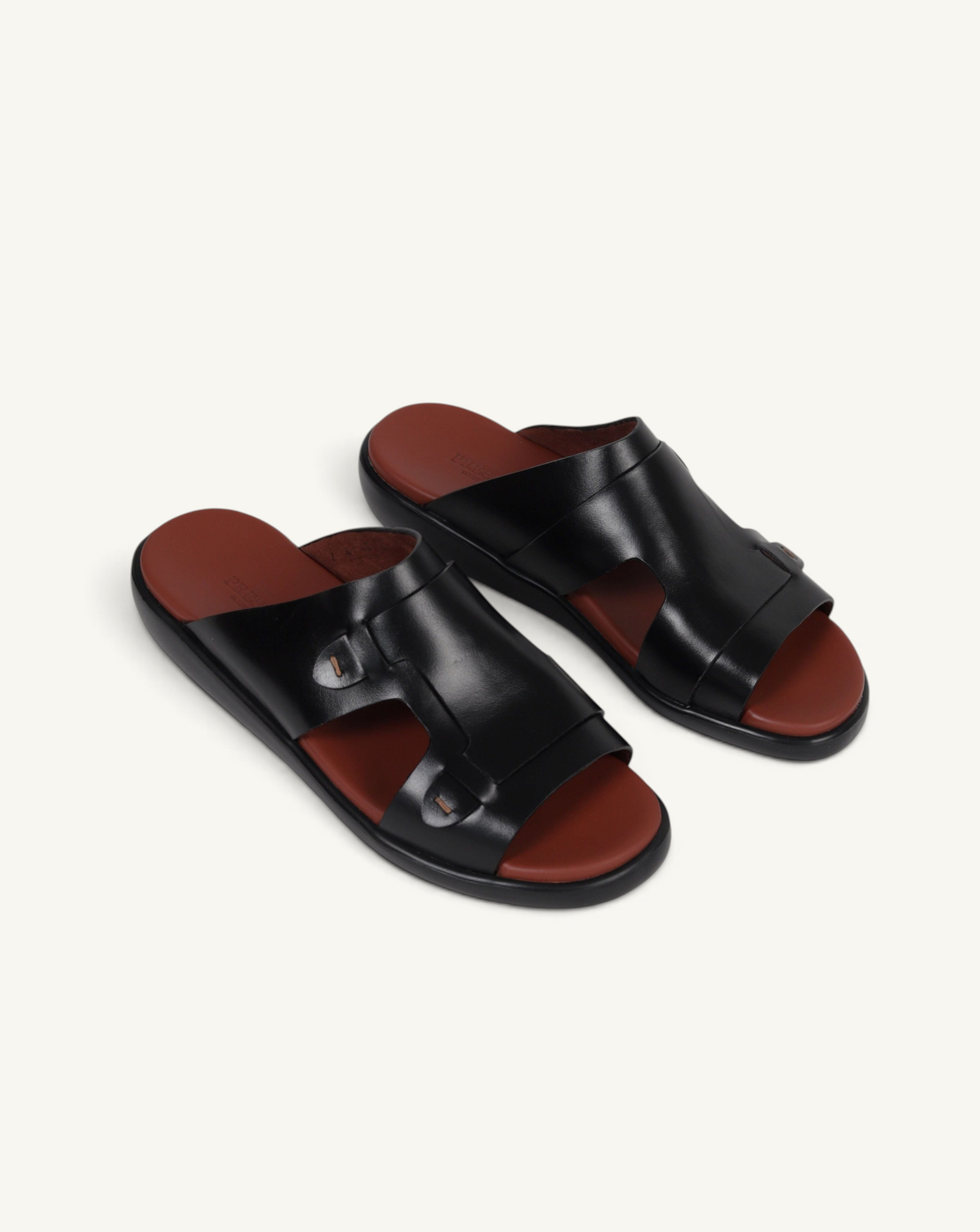 Prestige black soft nappa calf leather slide sandals with a contrasting brown footbed and cutout strap design.