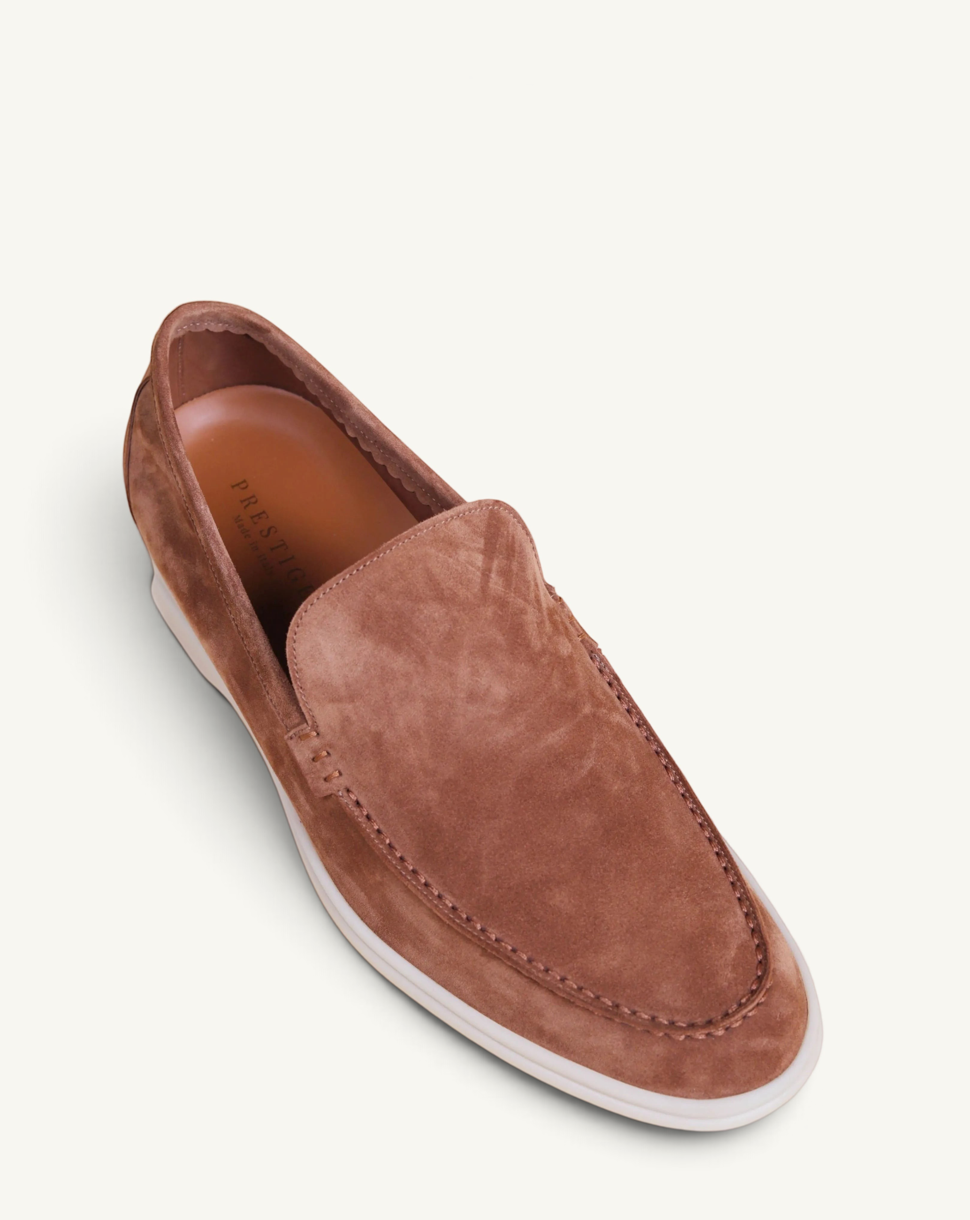 Prestige brown suede loafer with a white rubber sole, featuring a classic slip-on design and moccasin-style stitching.