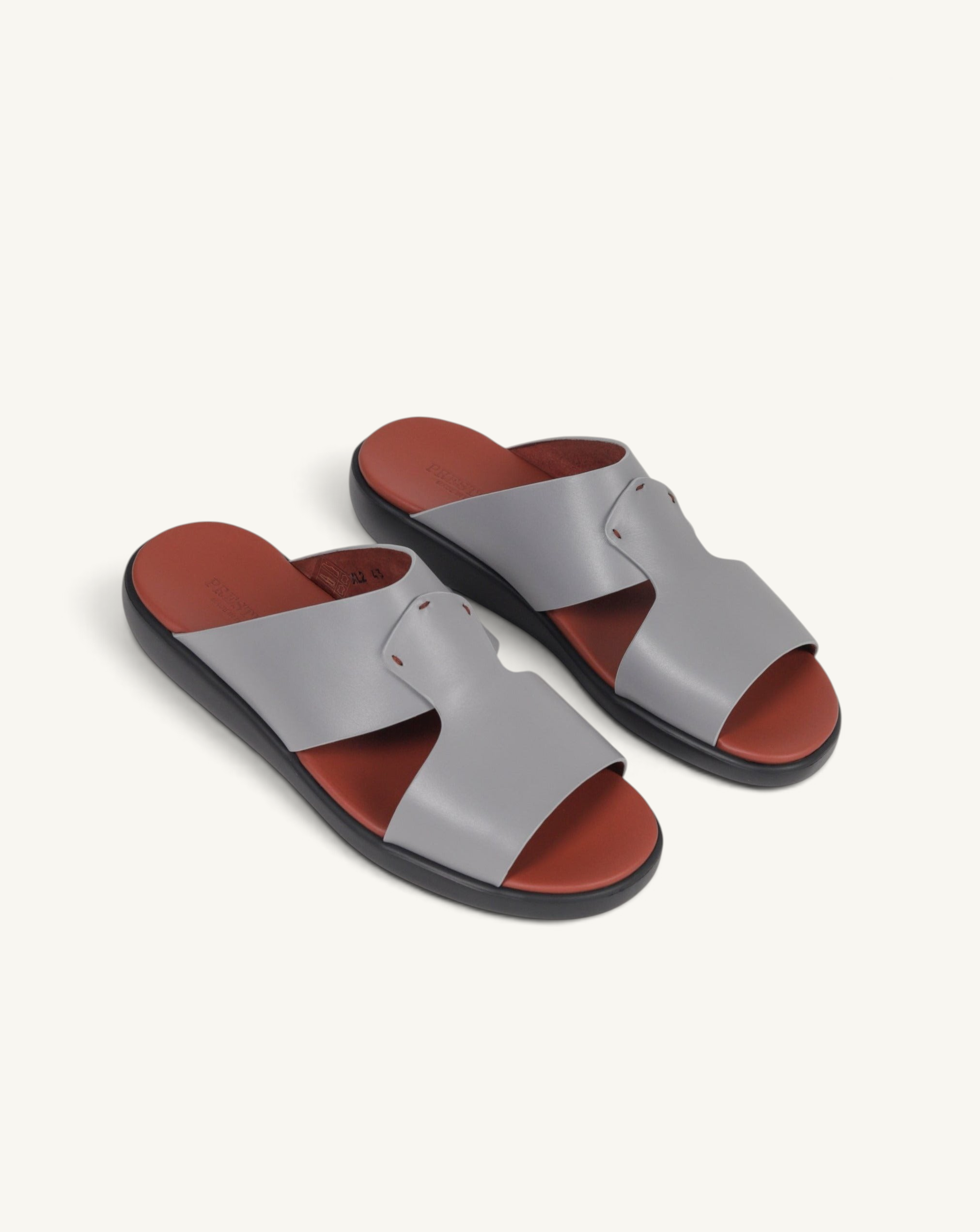 Prestige grey soft nappa calf leather slide sandals with a contrasting terracotta footbed and black sole.