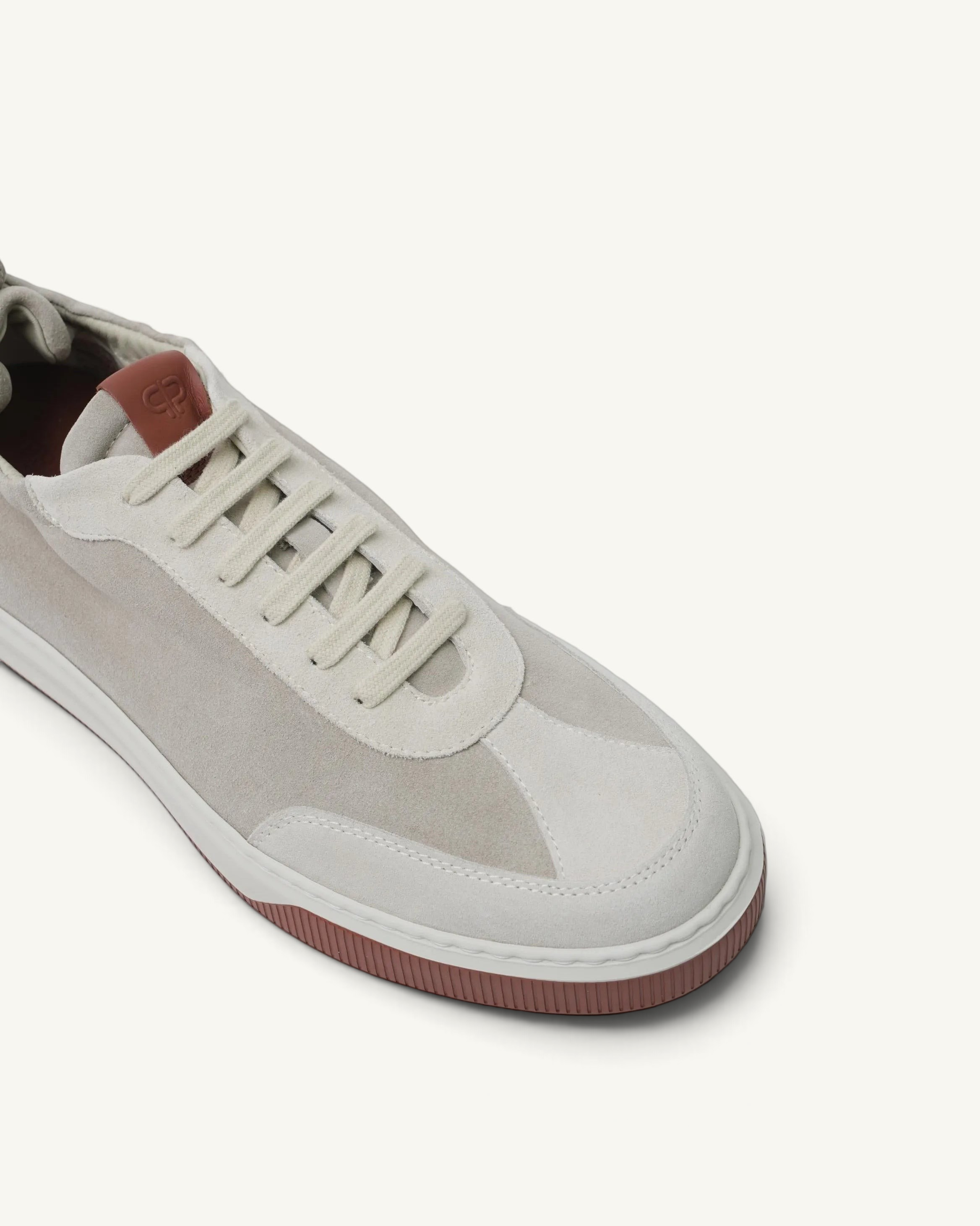 Prestige Legacy Walk Reverse men's sneaker in beige suede with a contrasting dark red rubber sole and tongue patch.