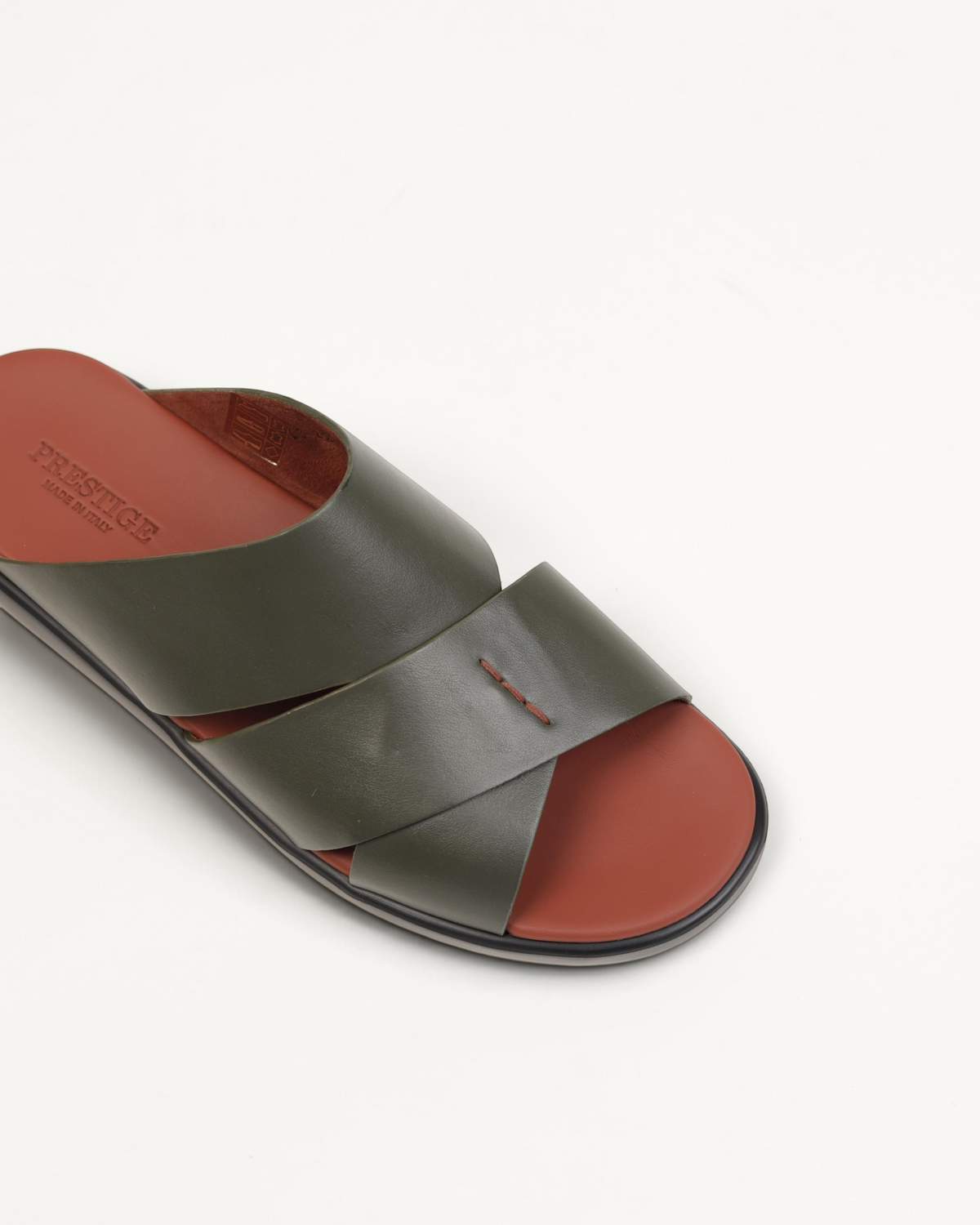 Prestige pistachio green leather slide sandals with a cross-strap design and contrast terracotta footbed