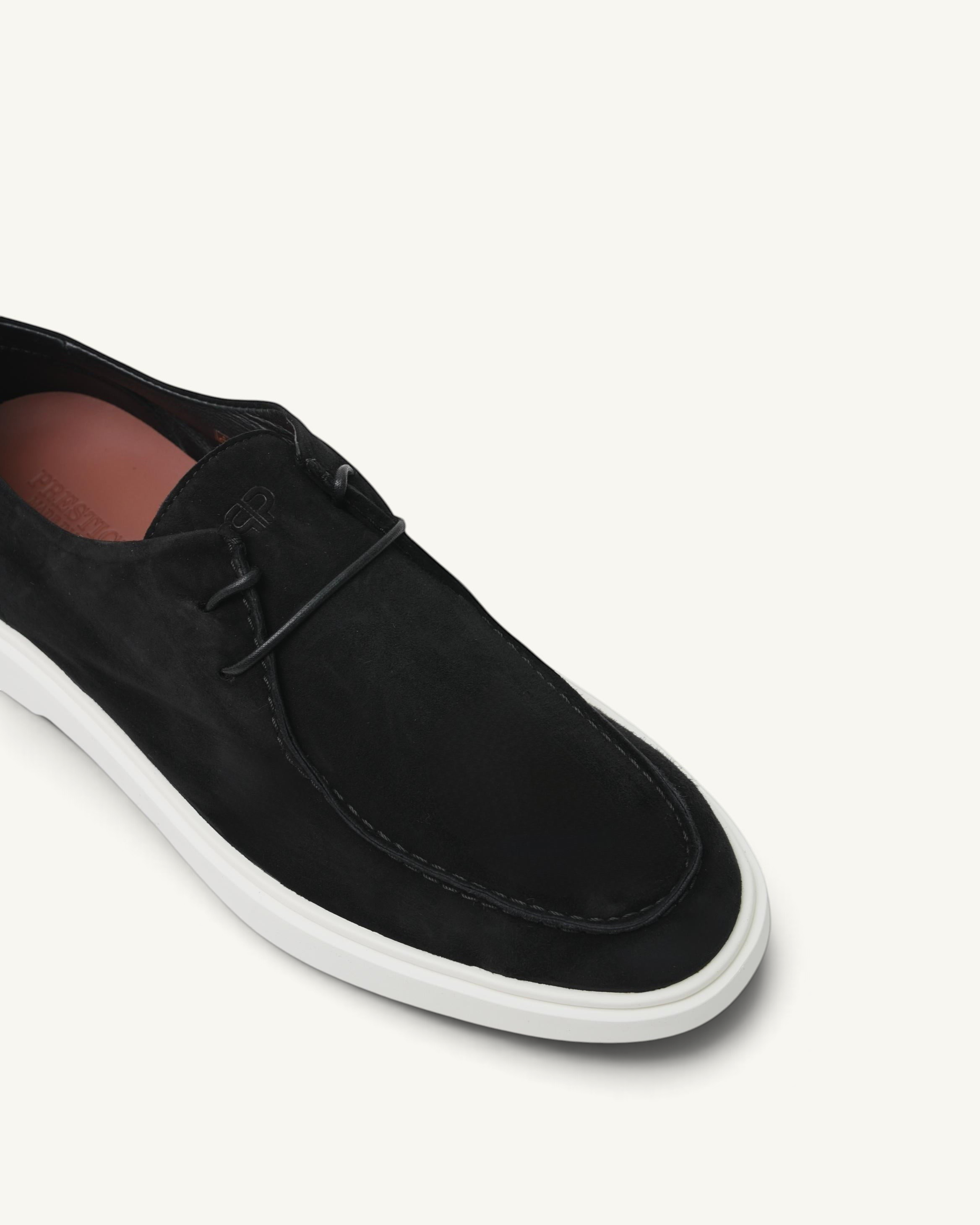 Prestige Playtime Reverse men's black suede loafer with a white rubber sole and minimalist lace-up detail.