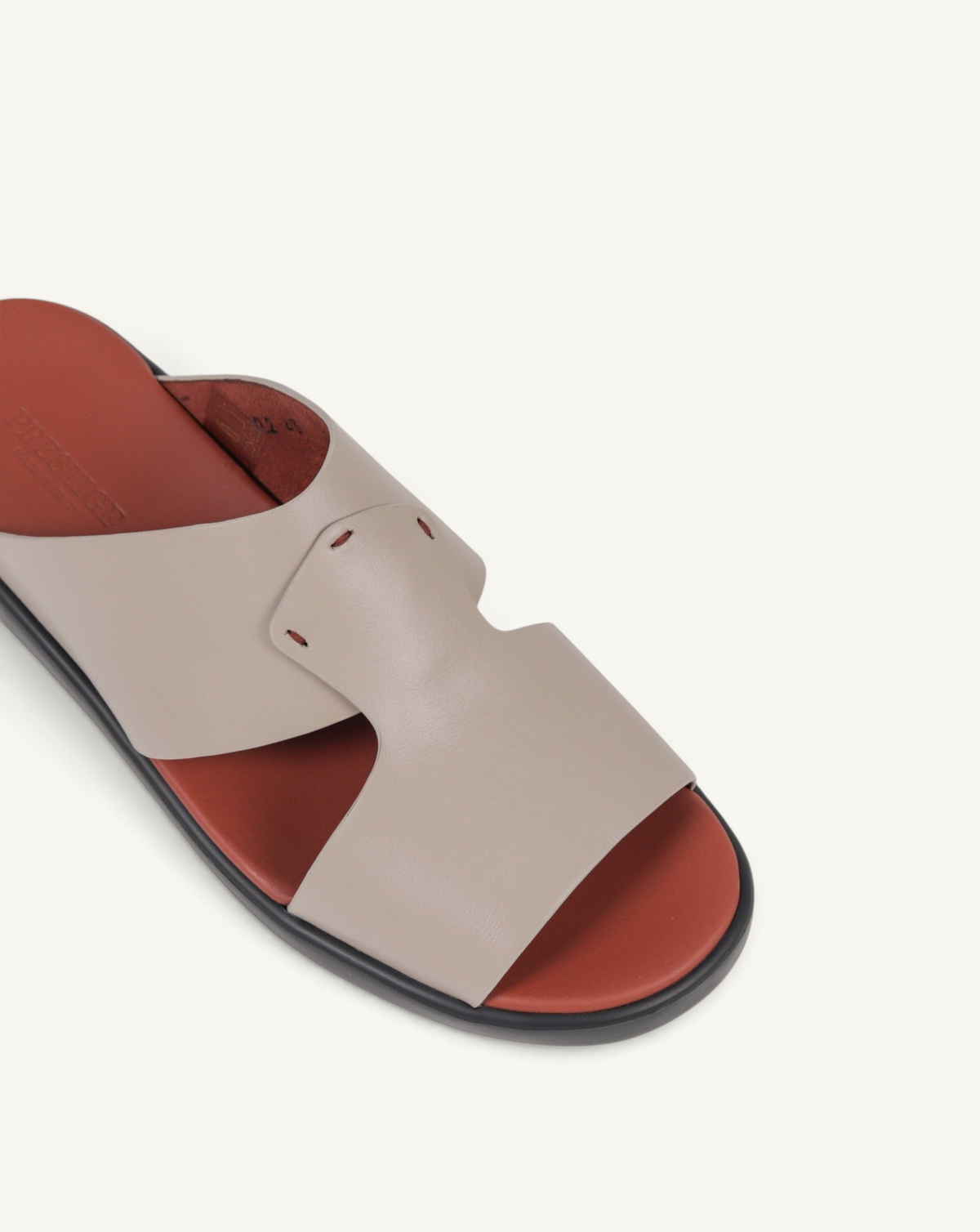 Prestige taupe soft nappa calf leather slide sandal with a contrasting terracotta footbed and black sole.